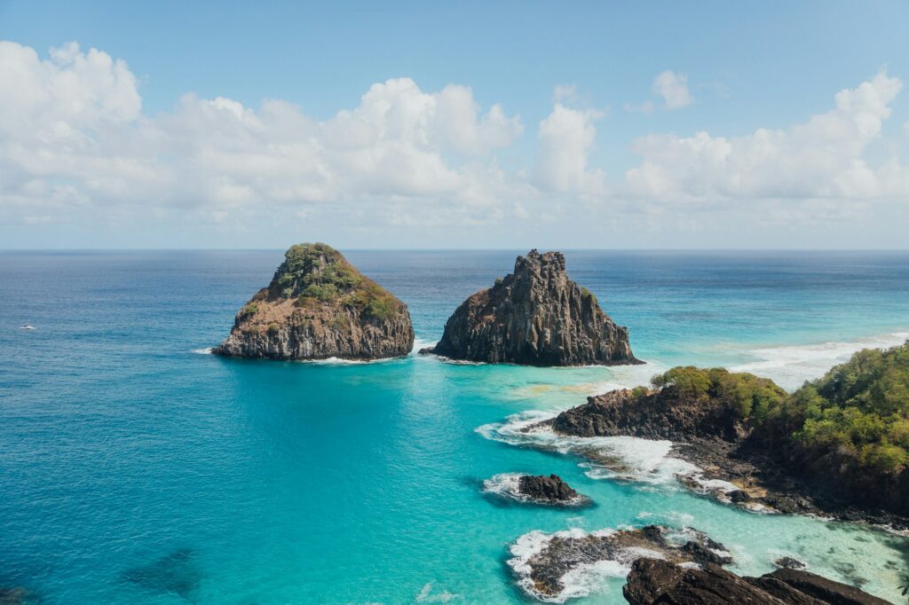 Morro Dois Irmãos e mar azul na Baía dos Porcos, em Fernando de Noronha