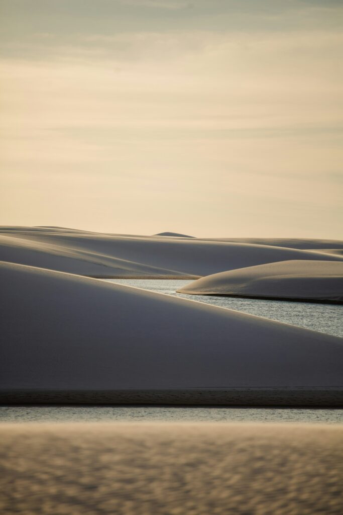Lagoa de água azul entre dunas brancas no Parque Nacional dos Lençóis Maranhenses