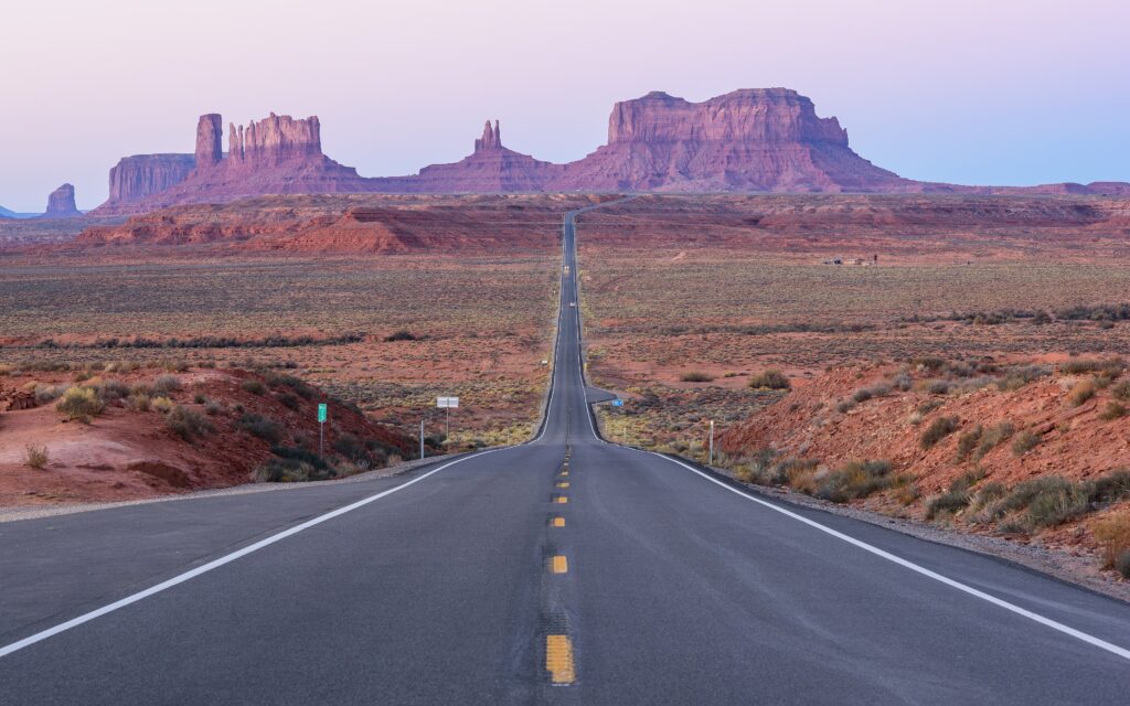 Estrada reta rumo às formações rochosas de Monument Valley, nos Estados Unidos