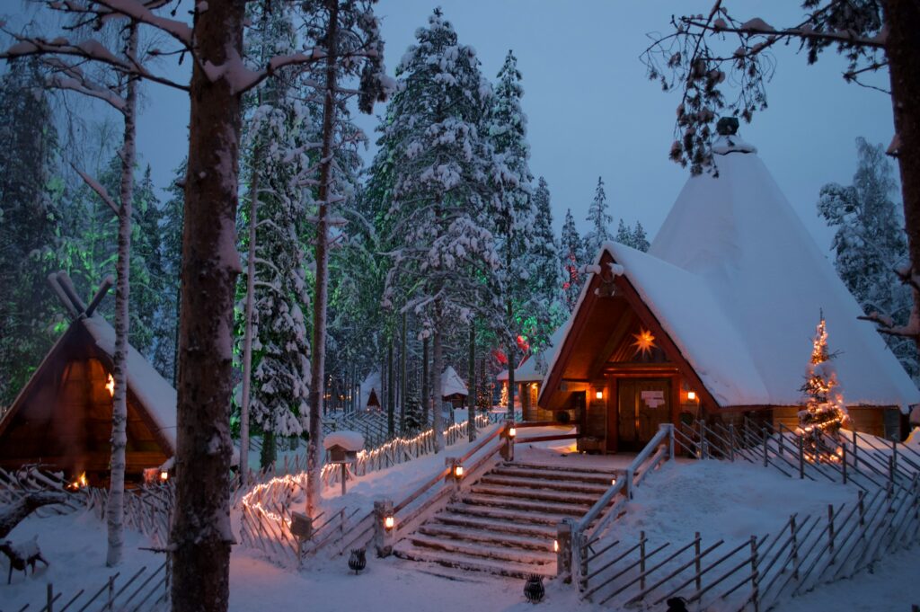 Cabana iluminada com luzes de Natal na neve, em Rovaniemi