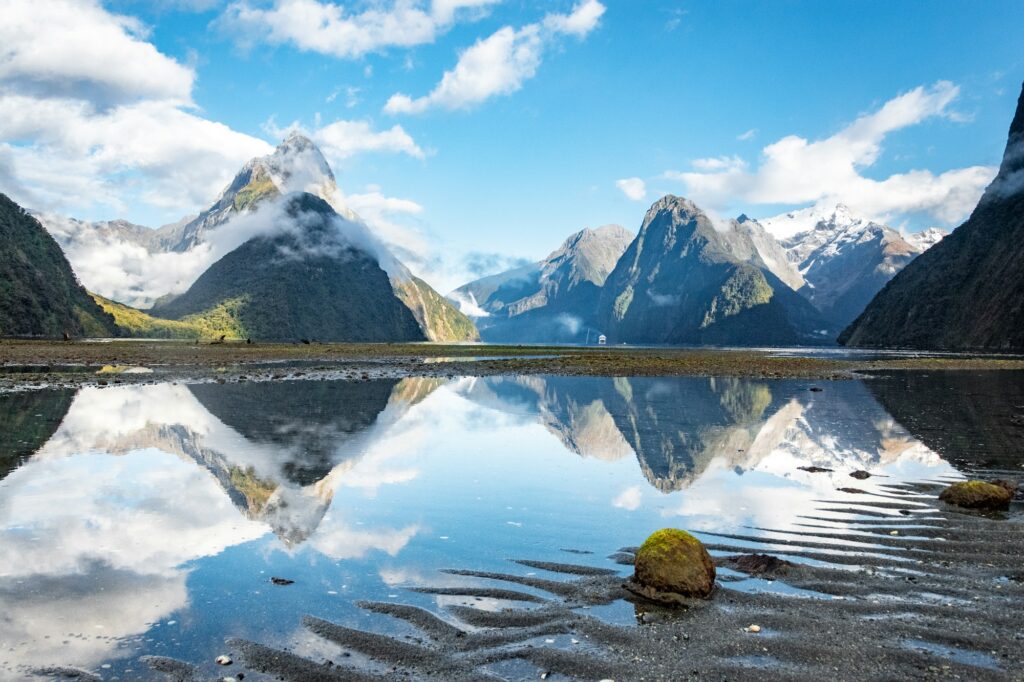 Montanhas refletidas na água em Milford Sound, na Nova Zelândia