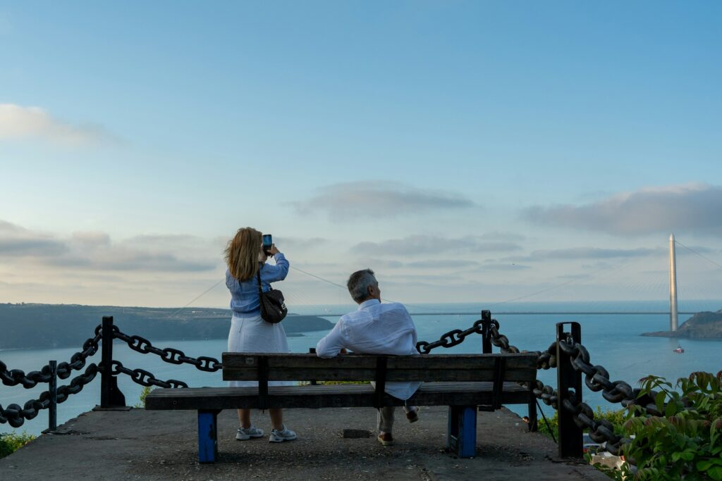 Casal sentado em um banco de mirante admirando a paisagem